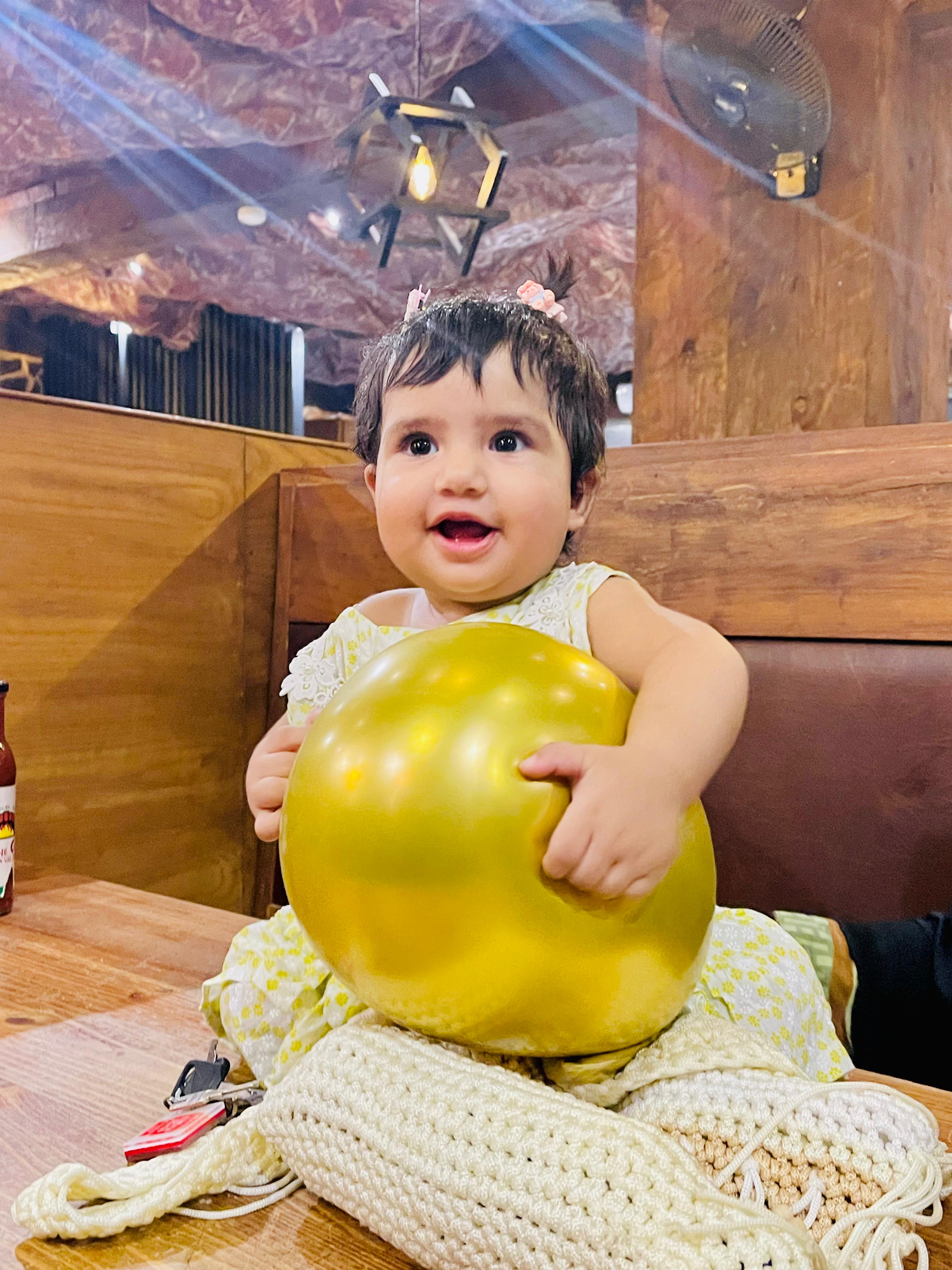 Hoorish Fatima smiling and holding a golden balloon